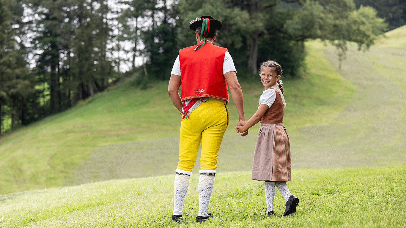 Senn und Mädchen in Appenzeller Tracht in der Natur